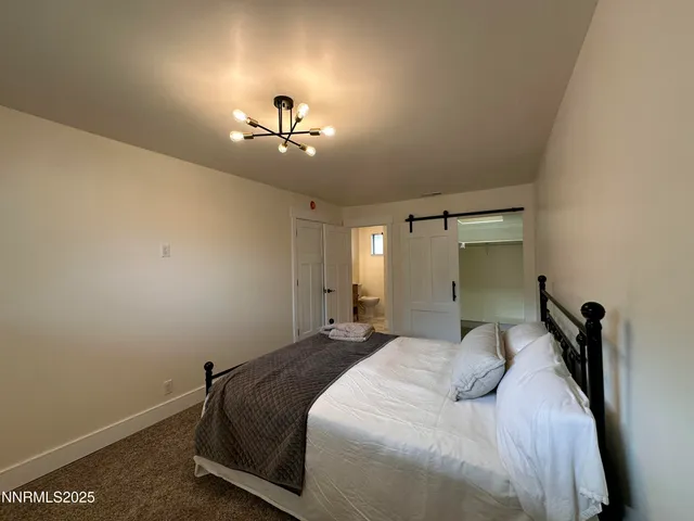 a bedroom with a bed and a chandelier fan