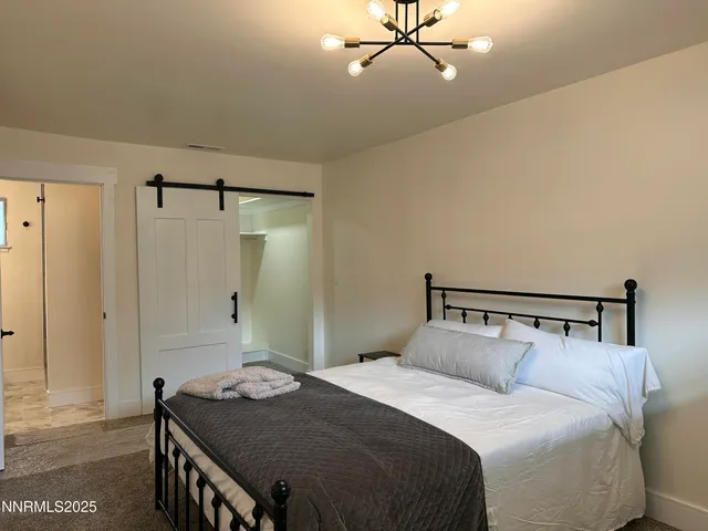 a bedroom with a bed and a chandelier