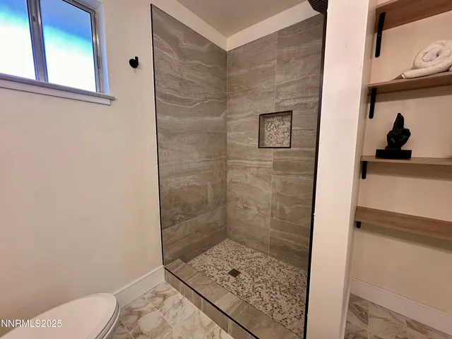 a bathroom with a toilet and a shower