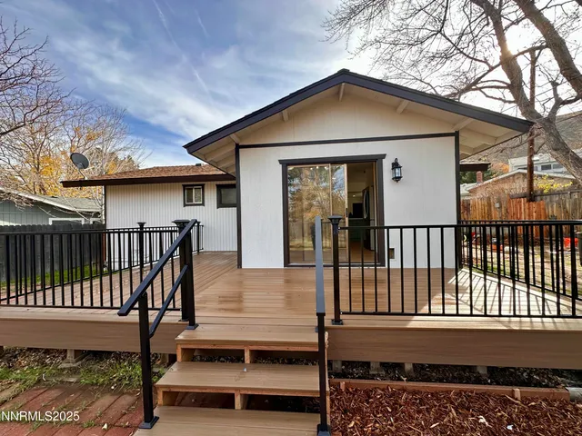 a view of a house with wooden fence next to a road