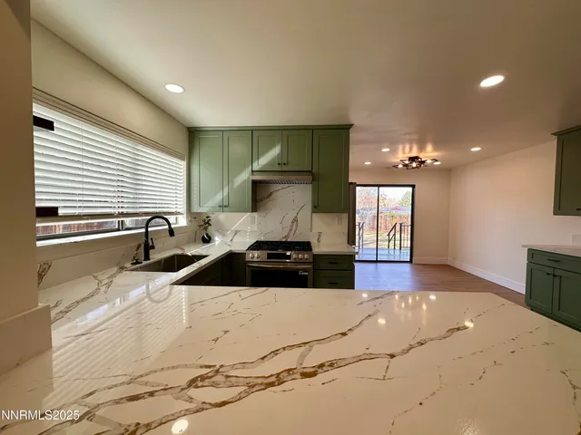 a kitchen with stainless steel appliances granite countertop a sink stove and cabinets