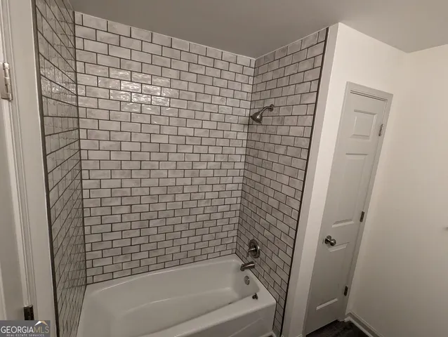 an empty room with chandelier fan and windows