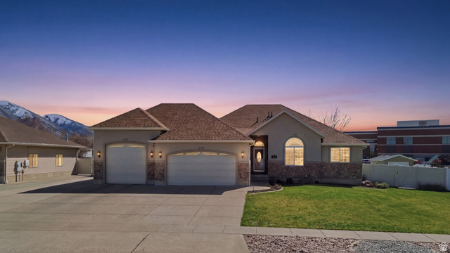 860 West 2980th Street South Logan, UT 84321 - Photo 1 of 38 Ranch-style residence featuring a stucco and stone veneer exterior, an arched entry, and two garage bays with carriage-style doors