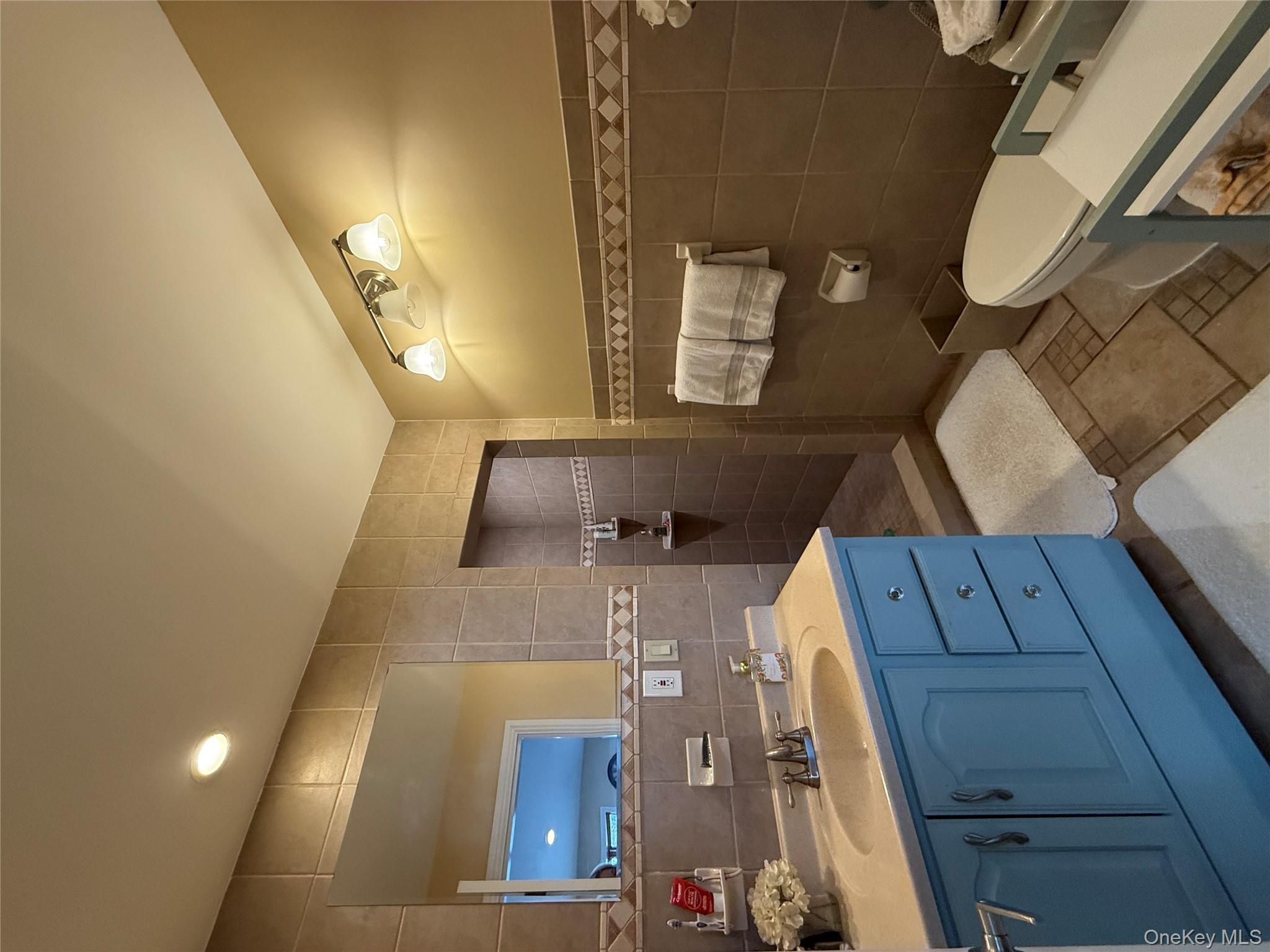 57 Laurel Road Lindenhurst, NY 11757 - Photo 8 of 24 a spacious bathroom with a double vanity sink toilet and mirror