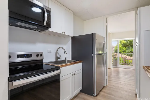 a kitchen with stainless steel appliances a refrigerator a stove and cabinets