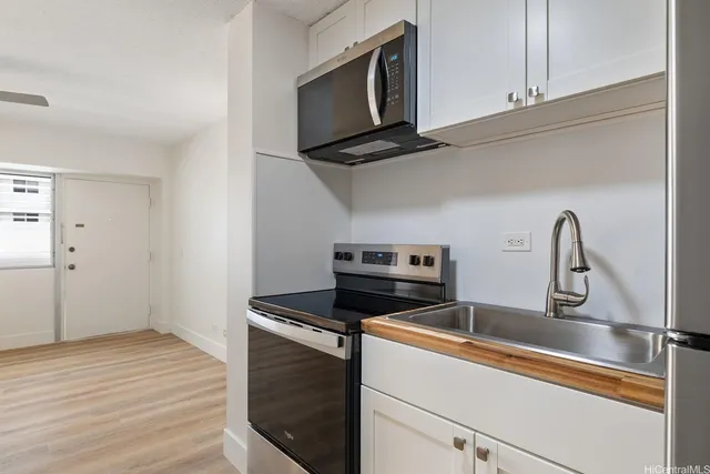 a kitchen with stainless steel appliances a stove microwave and sink