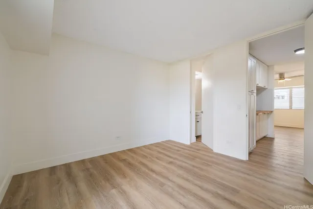 a view of empty room with wooden floor