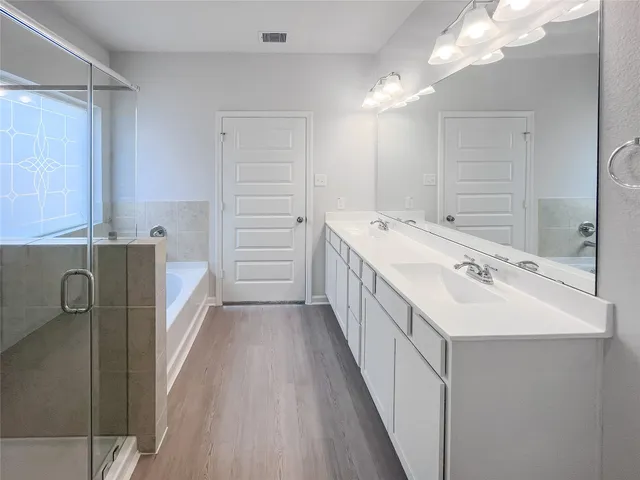 a bathroom with a double vanity sink mirror and shower