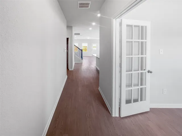 a view of a hallway with wooden floor and entryway