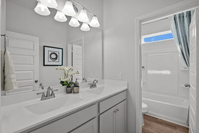 a bathroom with a sink a tub and a mirror