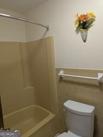 a bathroom with a toilet and a shower