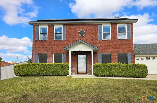 a front view of a house with yard and garage