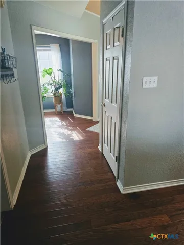 a view of hallway with livingroom and stairs