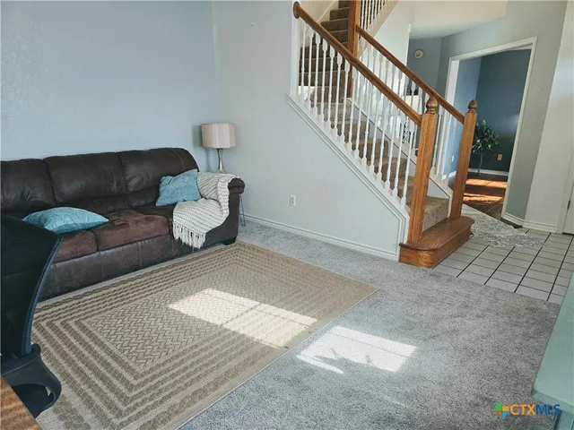 a living room with furniture and stairs