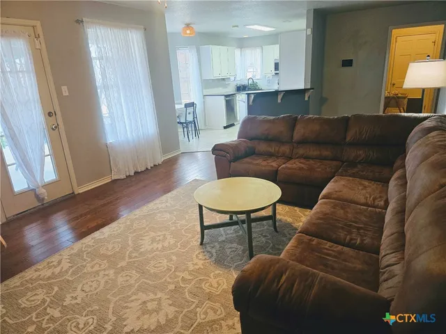 a living room with furniture and a wooden floor