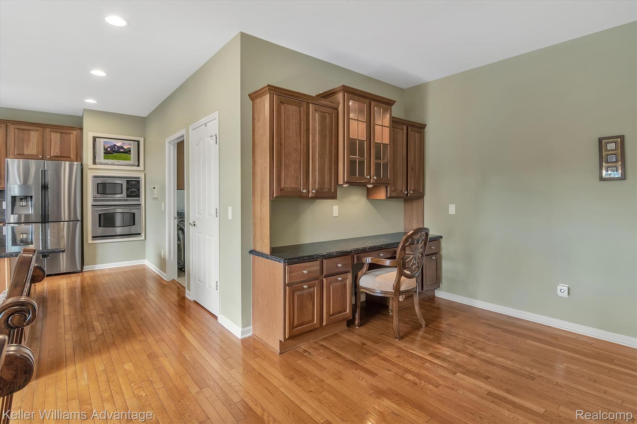 9042 Ridgefield Drive Brighton, MI 48114 - Photo 23 of 61 Built in custom made granite adorned desk with glass lit cabinets