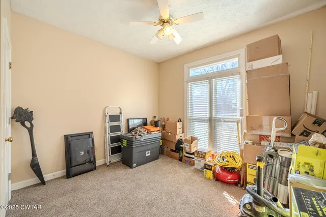a view of a bedroom with workspace and a window
