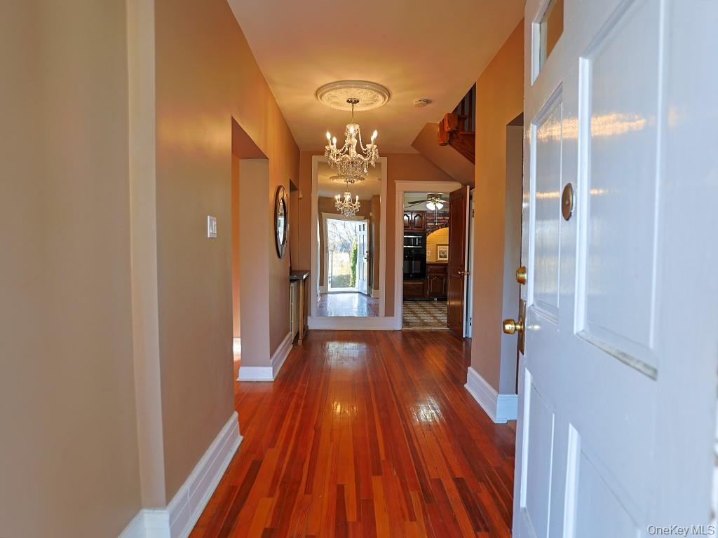 113 Hooker Avenue Poughkeepsie, NY 12601 - Photo 11 of 49 Hallway featuring dark wood finished floors and a chandelier