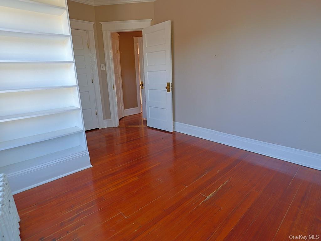 113 Hooker Avenue Poughkeepsie, NY 12601 - Photo 21 of 49 Spare room featuring dark wood-style floors and baseboards