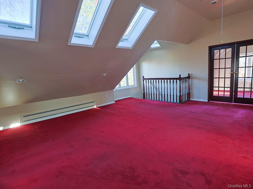 113 Hooker Avenue Poughkeepsie, NY 12601 - Photo 22 of 49 Additional living space featuring vaulted ceiling, baseboard heating, carpet, french doors, and a skylight