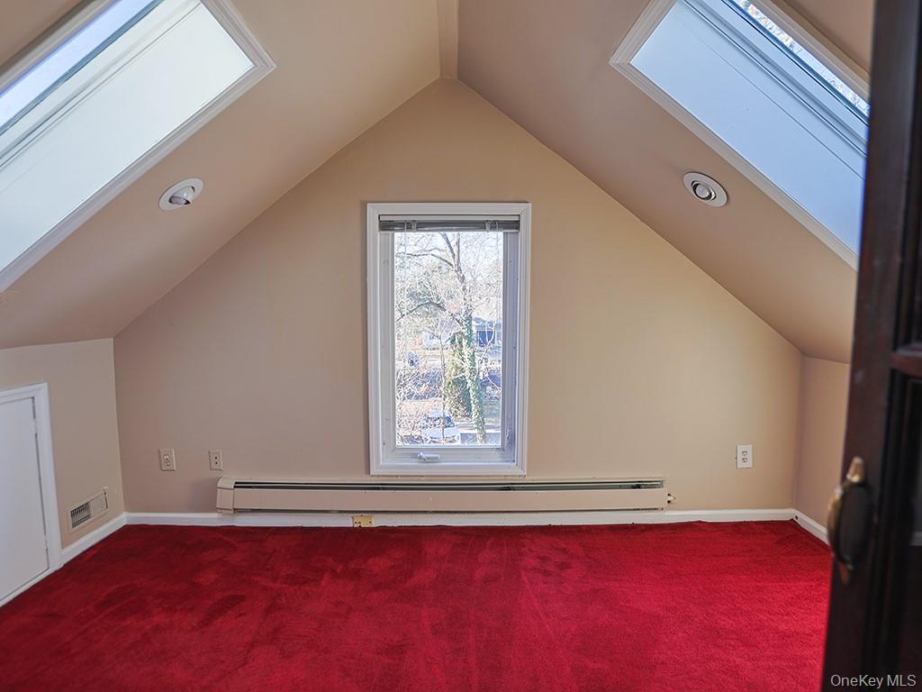 113 Hooker Avenue Poughkeepsie, NY 12601 - Photo 24 of 49 Additional living space featuring a skylight, a baseboard radiator, lofted ceiling, and carpet flooring