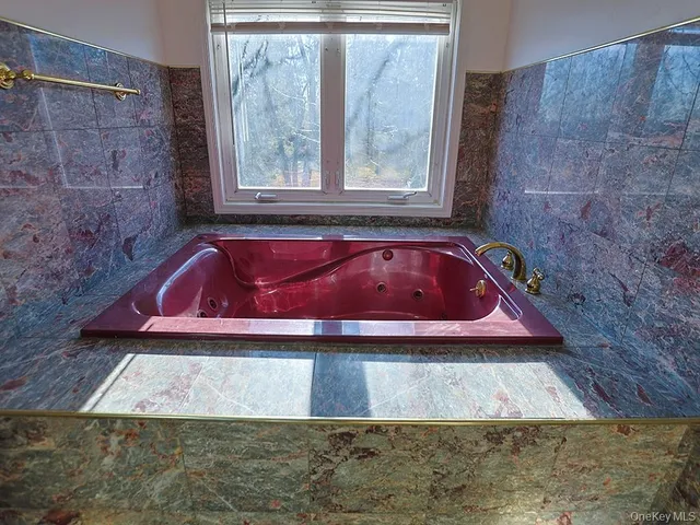 a white bath tub sitting in a bathroom next to a window