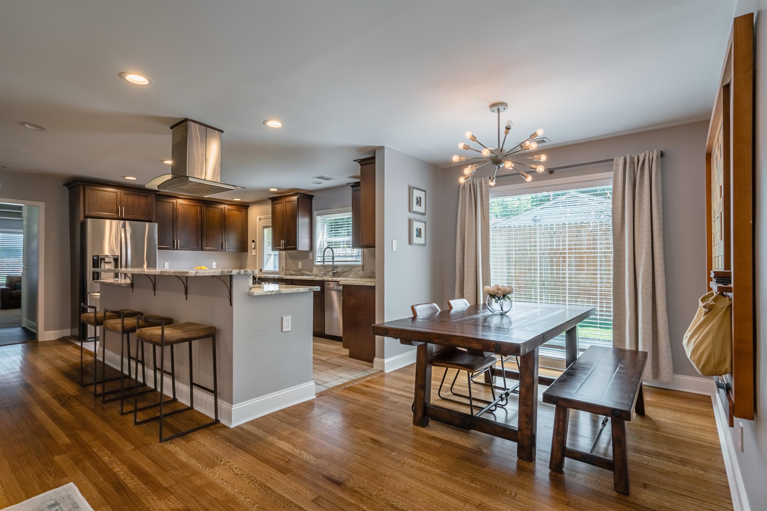 367 Green Acres Road Memphis, TN 38117 - Photo 3 of 27 a kitchen with stainless steel appliances a dining table chairs and wooden floor