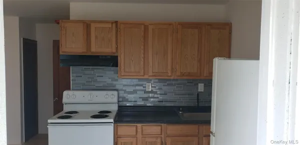a kitchen with granite countertop white cabinets and stainless steel appliances