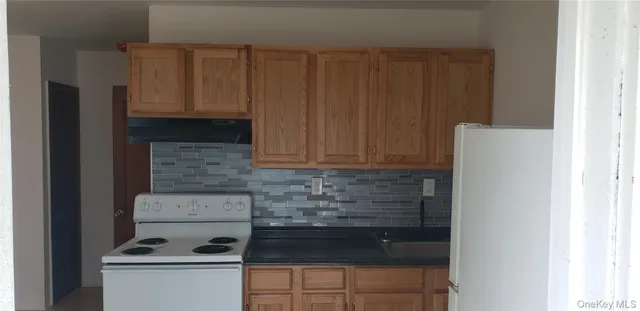 a kitchen with granite countertop white cabinets and stainless steel appliances