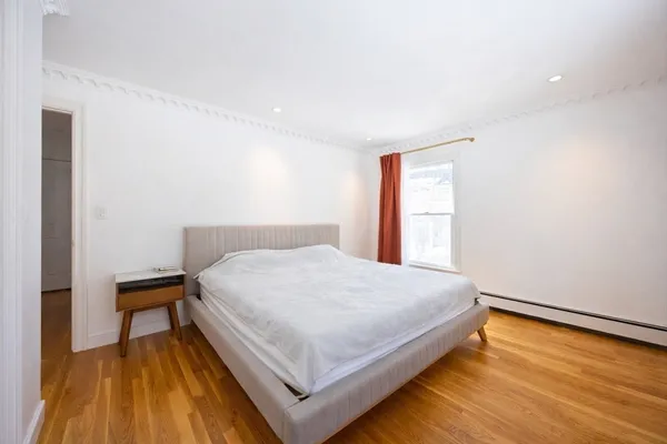 a large bed sitting in a bedroom next to a window