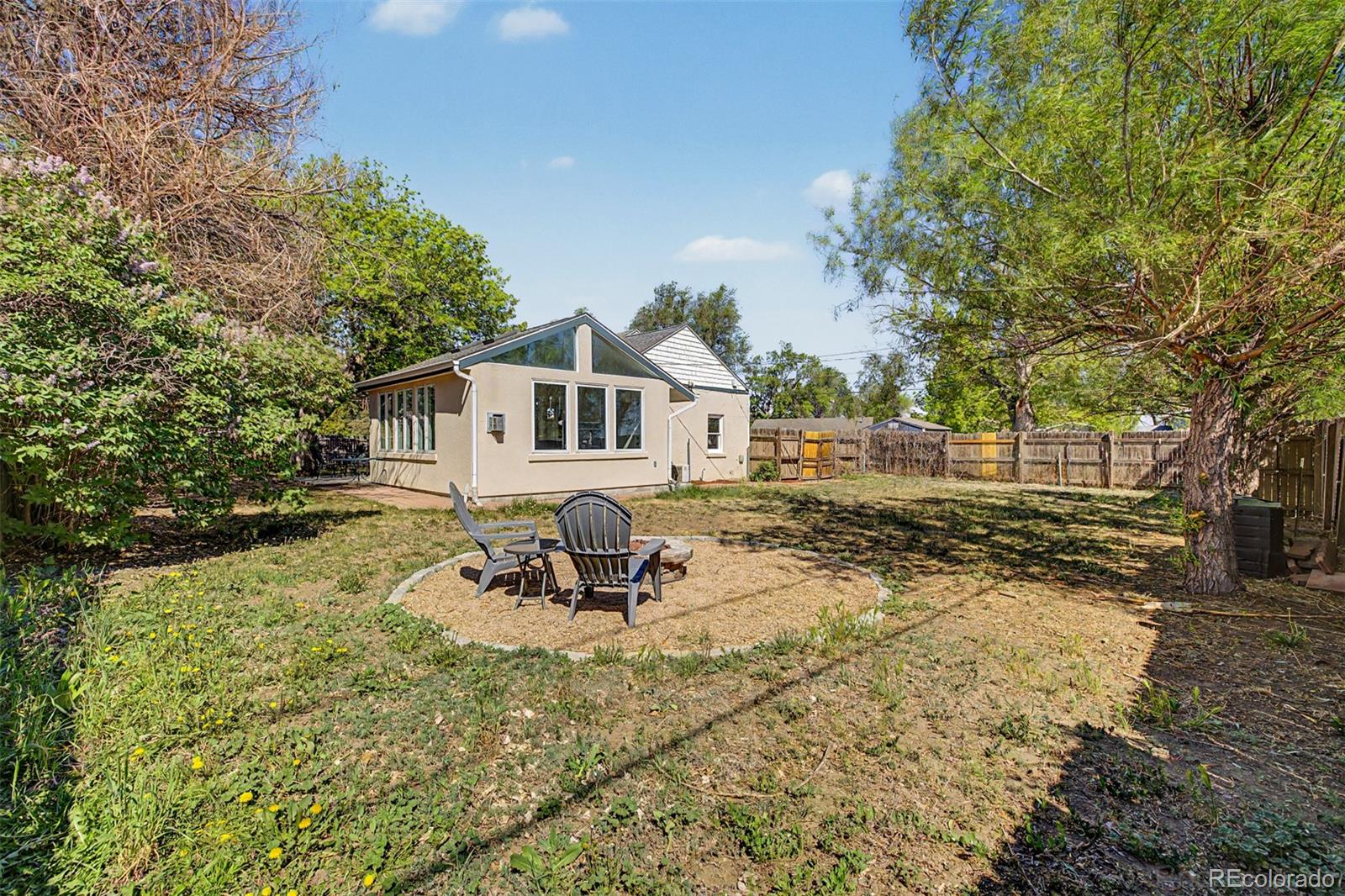 6790 West 48th Avenue Wheat Ridge, CO 80033 - Photo 25 of 30 a view of a white house with a yard