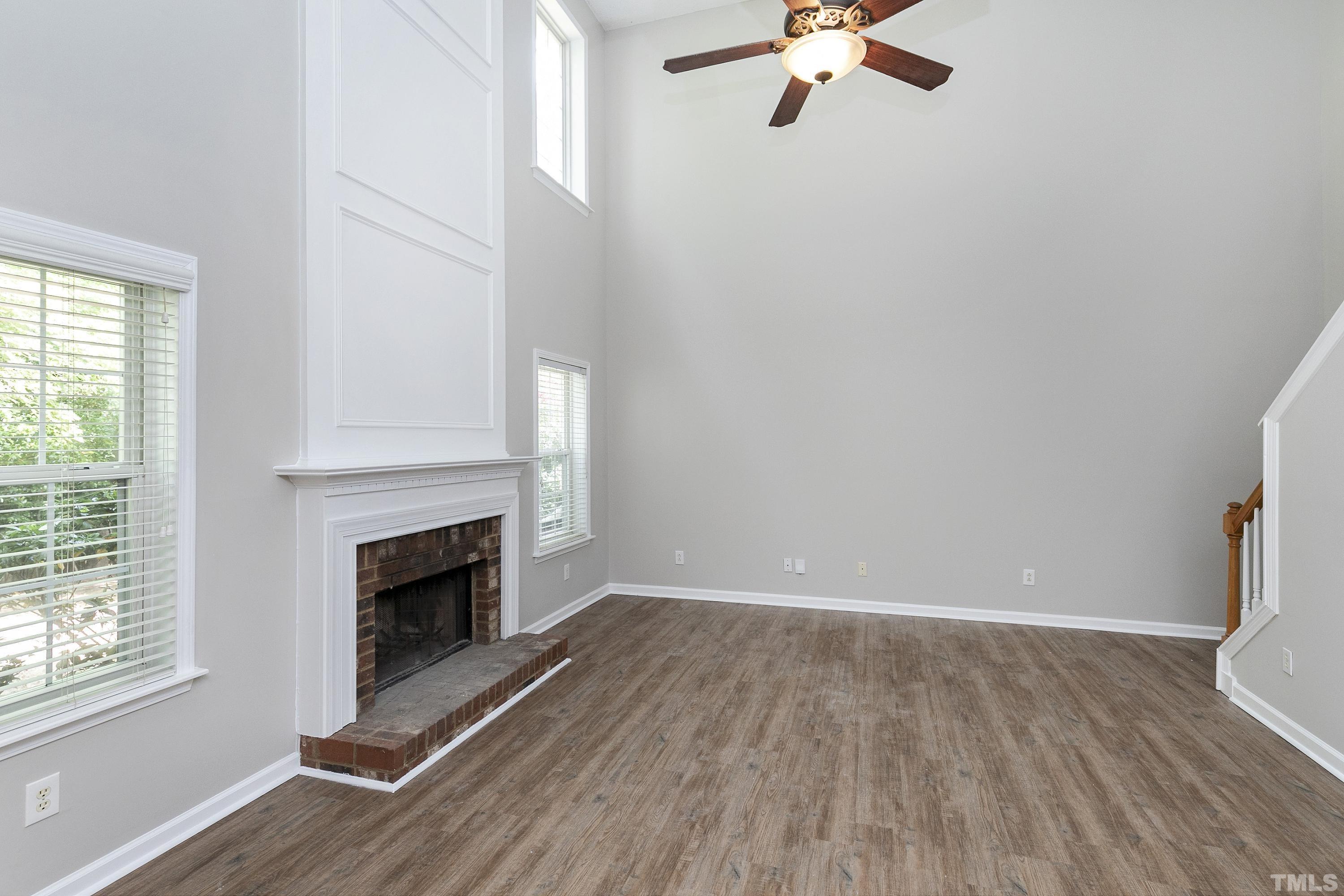 613 Branchview Drive Durham, NC 27713 - Photo 14 of 40 an empty room with wooden floor fireplace and windows