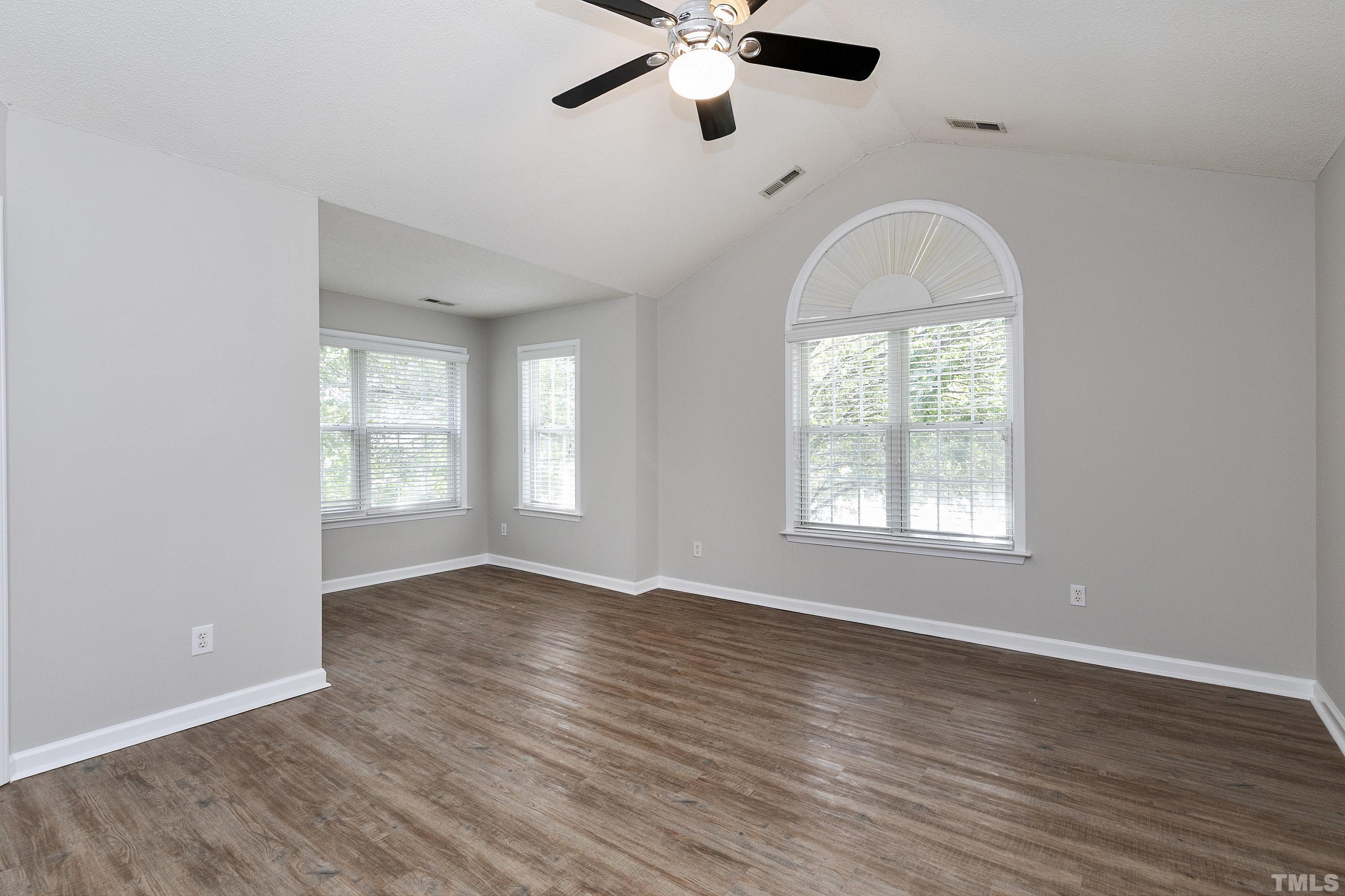 613 Branchview Drive Durham, NC 27713 - Photo 22 of 40 an empty room with wooden floor chandelier fan and windows