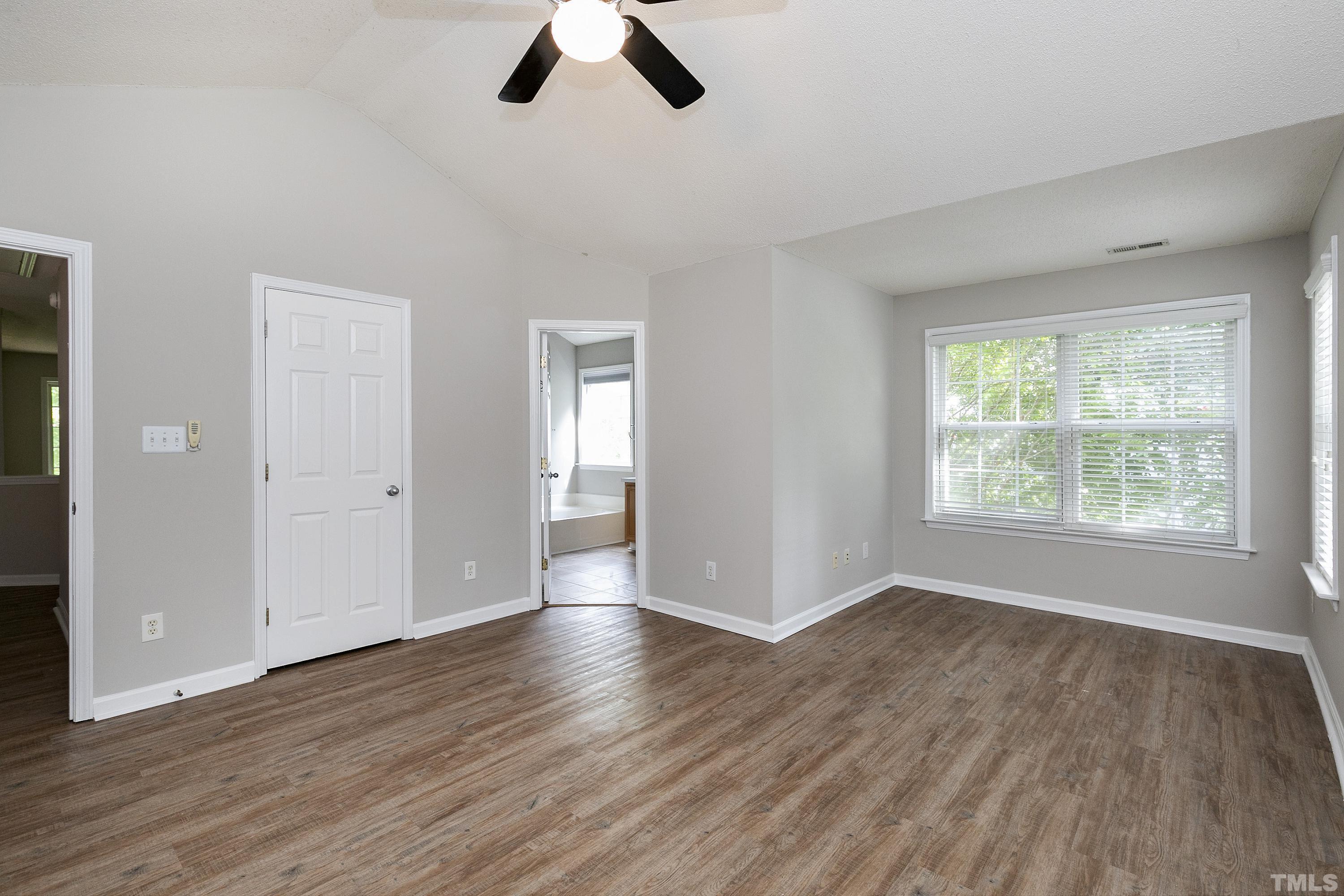 613 Branchview Drive Durham, NC 27713 - Photo 23 of 40 an empty room with wooden floor cabinet and windows