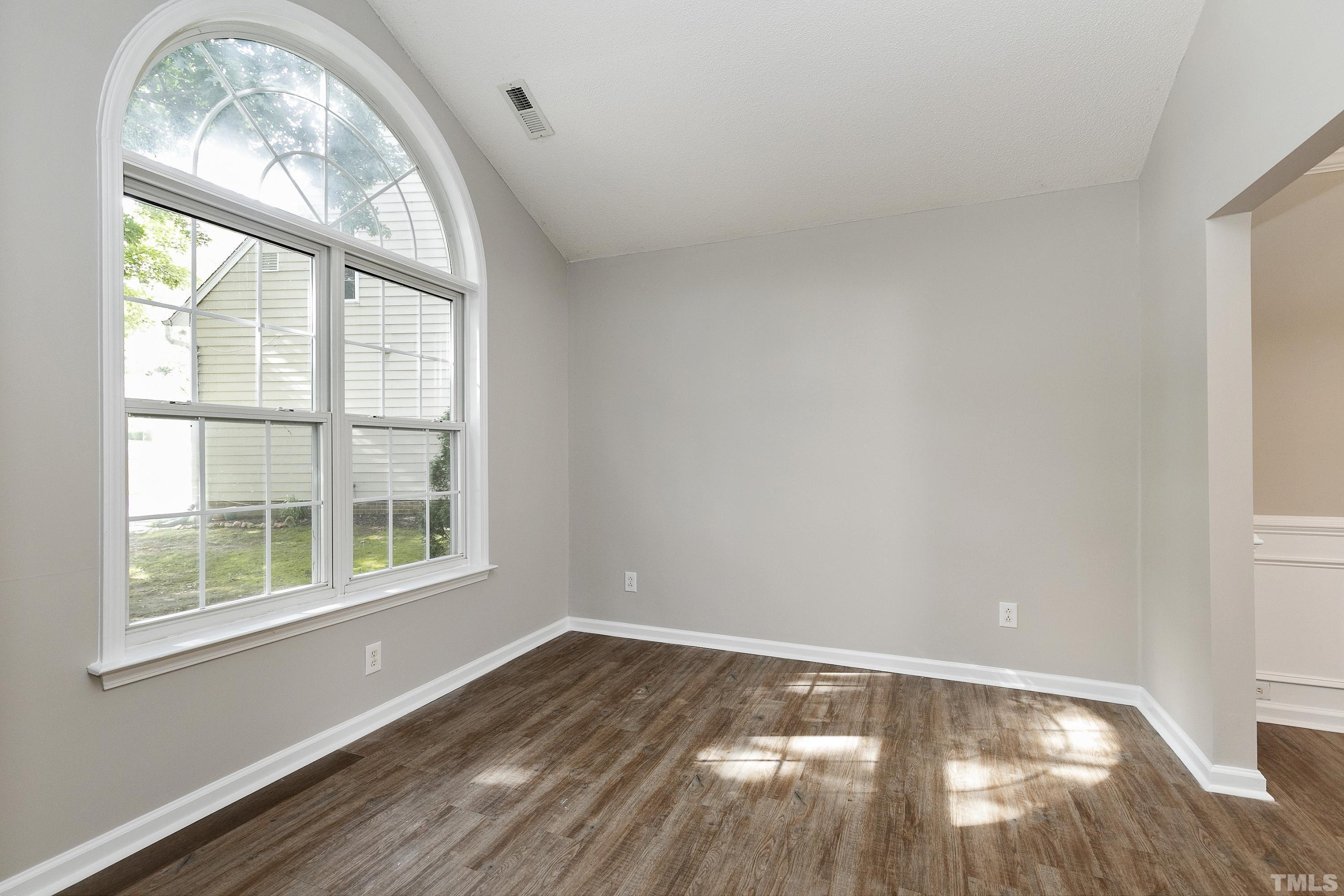 613 Branchview Drive Durham, NC 27713 - Photo 4 of 40 an empty room with wooden floor fan and windows