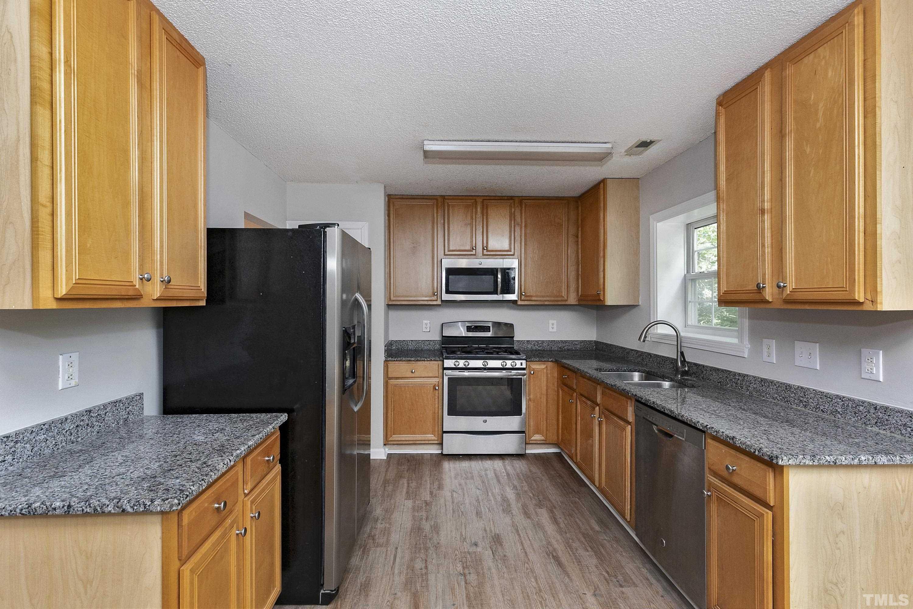 613 Branchview Drive Durham, NC 27713 - Photo 9 of 40 a kitchen with stainless steel appliances granite countertop a stove a sink dishwasher a refrigerator and a microwave oven