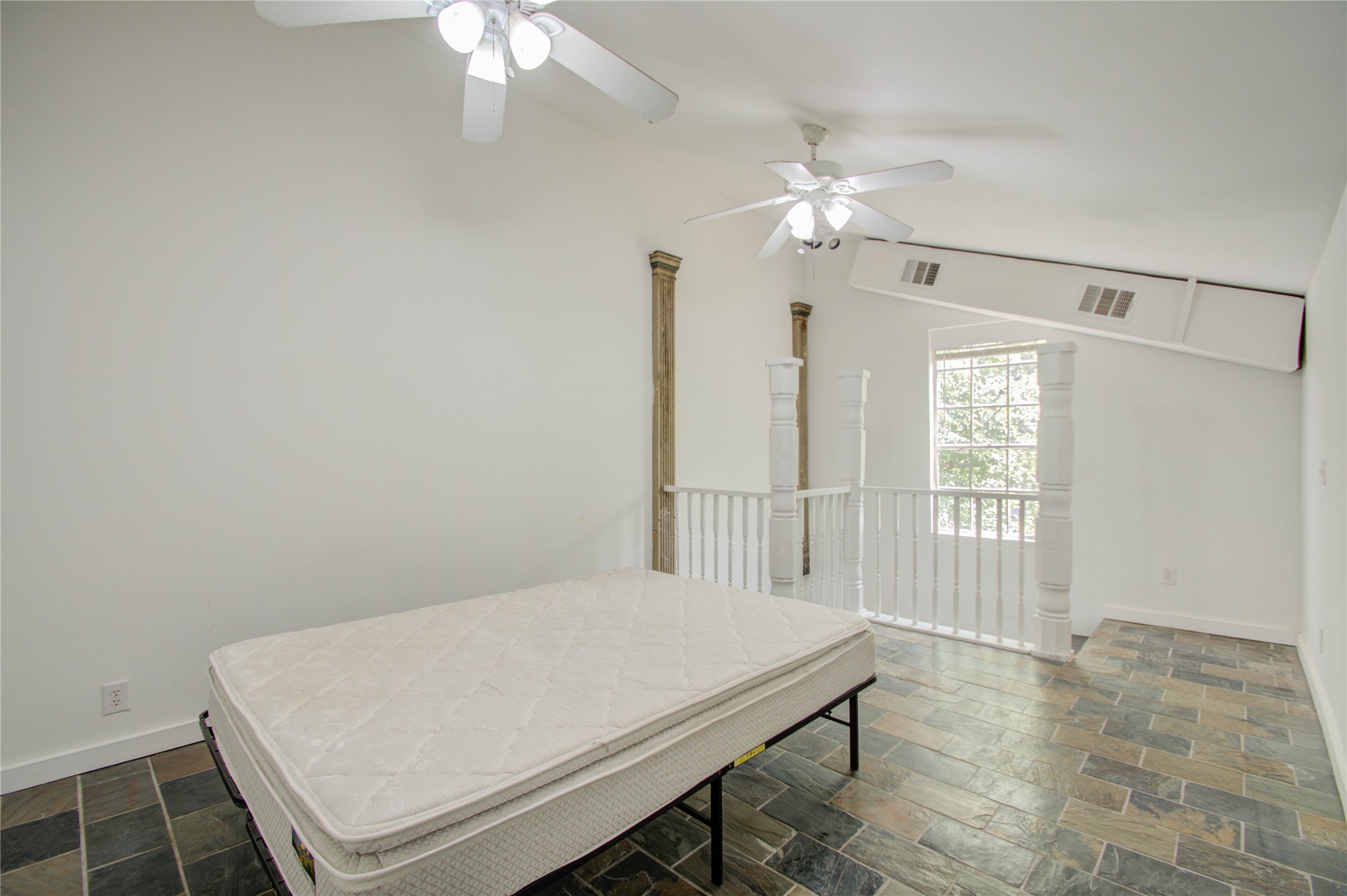 5311 Palmetto Street, Unit C Houston, TX 77081 - Photo 13 of 20 a bedroom with a bed and a chandelier