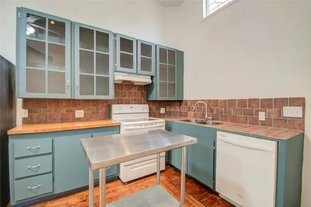 a kitchen with stainless steel appliances kitchen island wooden cabinets and entryway