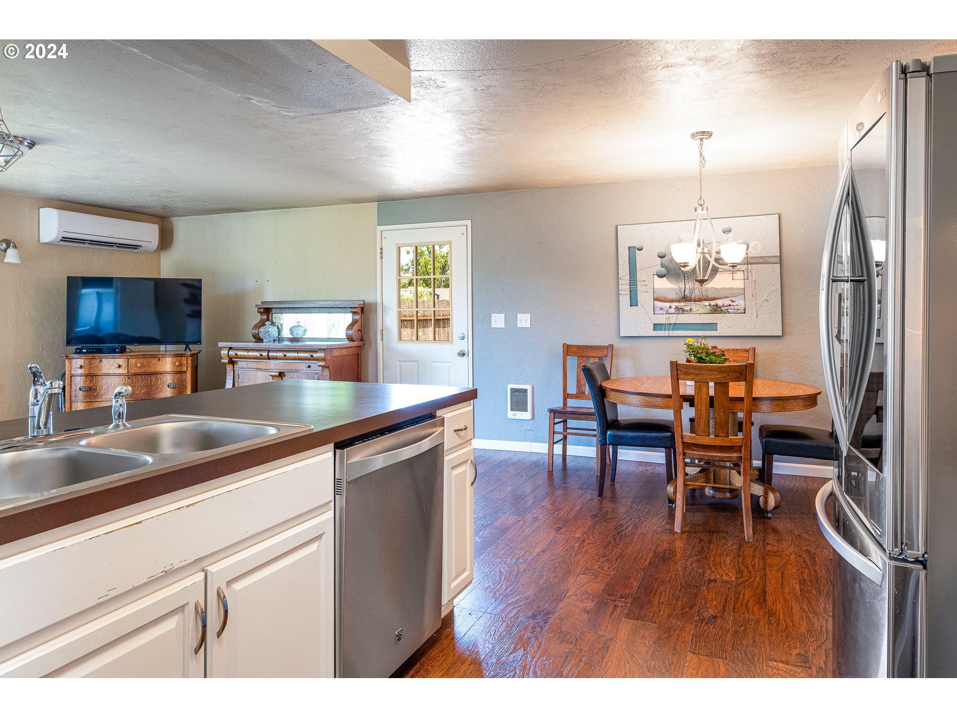 3870 Richland Street Springfield, OR 97478 - Photo 36 of 41 a kitchen with stainless steel appliances granite countertop a refrigerator a stove a sink a dining table and chairs with wooden floor