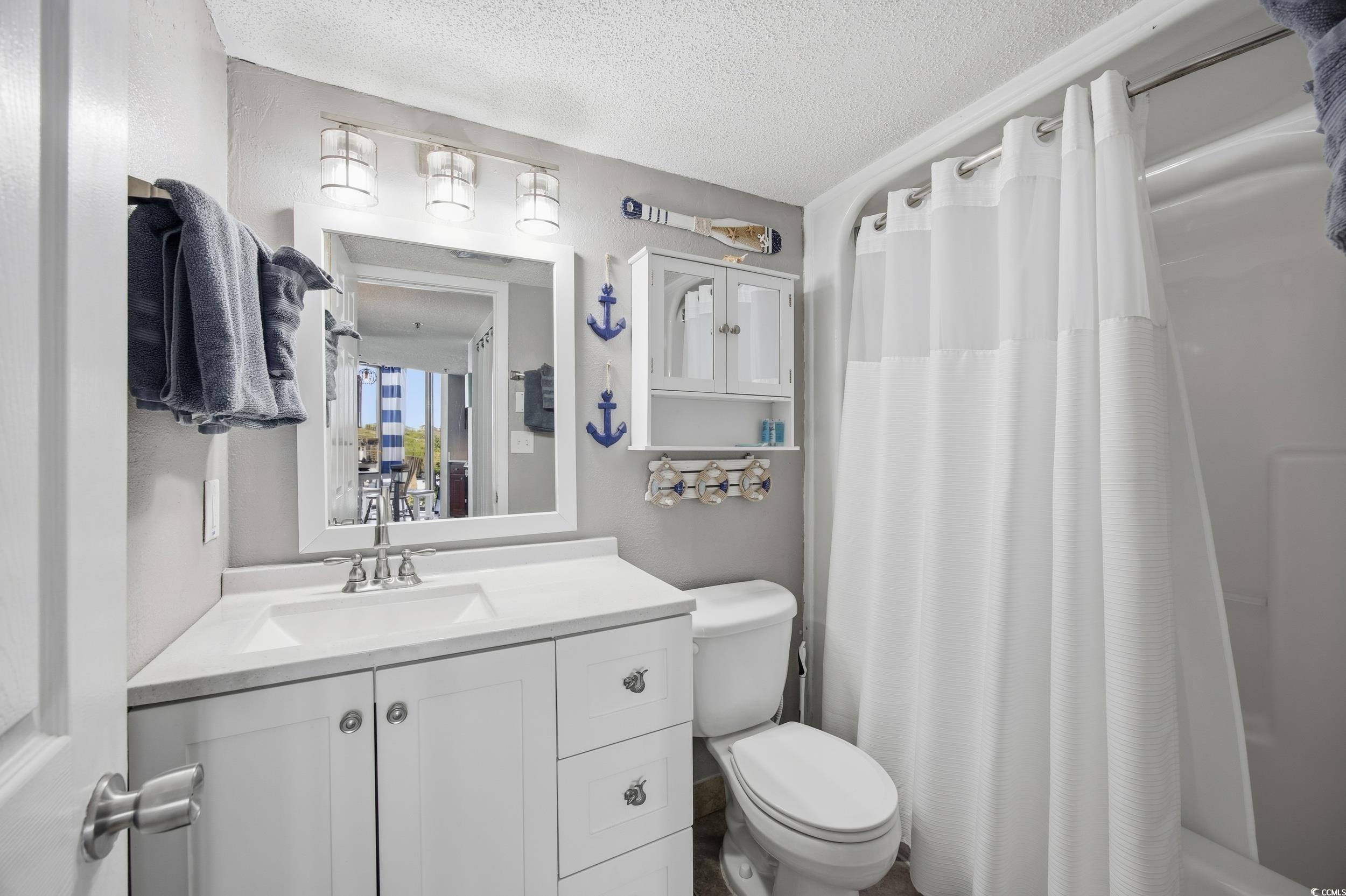 2710 North Ocean Boulevard, Unit 702 Myrtle Beach, SC 29577 - Photo 11 of 38 Full bathroom with a textured ceiling, vanity, and shower / tub combo