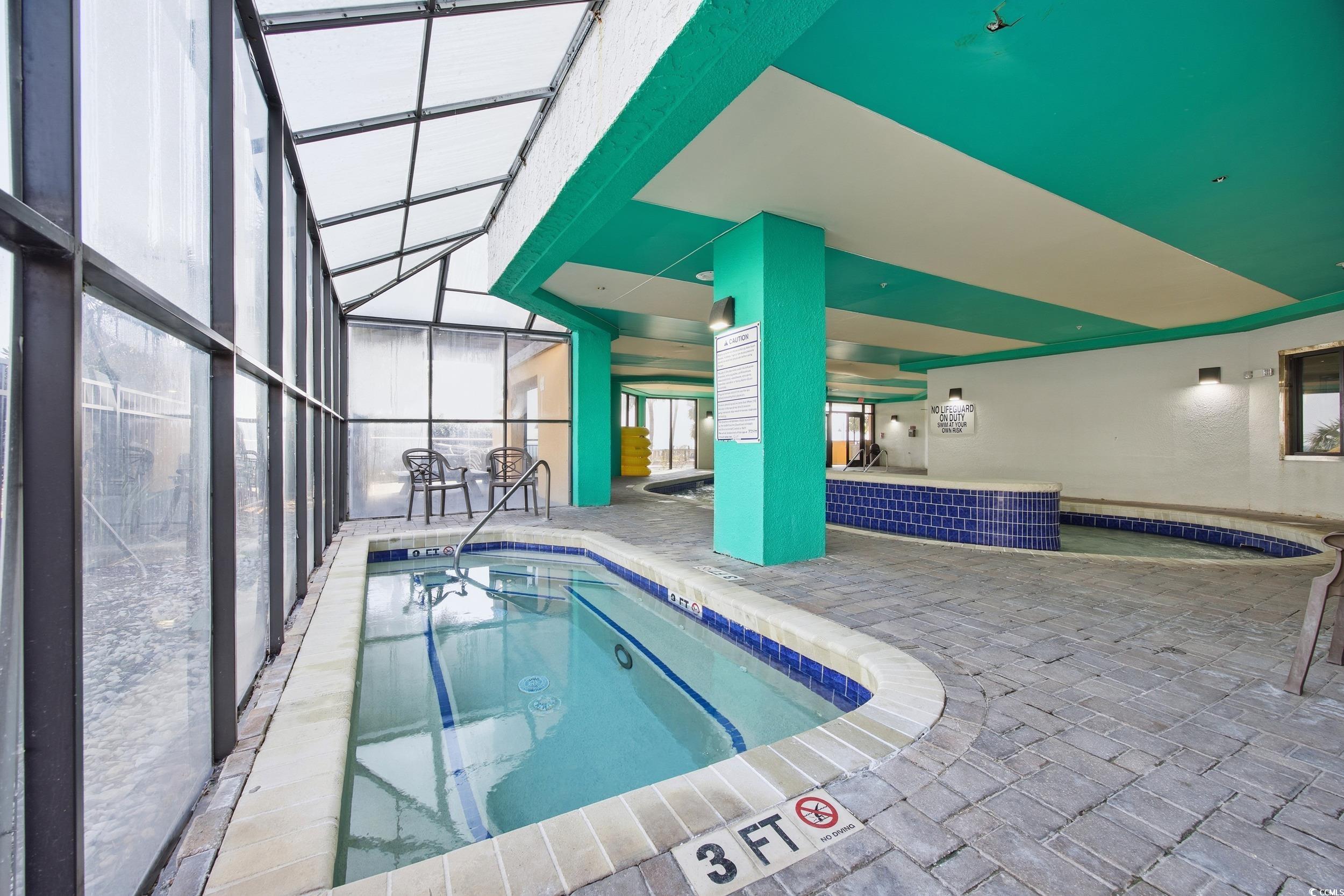 2710 North Ocean Boulevard, Unit 702 Myrtle Beach, SC 29577 - Photo 23 of 38 Indoor community pool with a patio area, a sunroom, and a lanai
