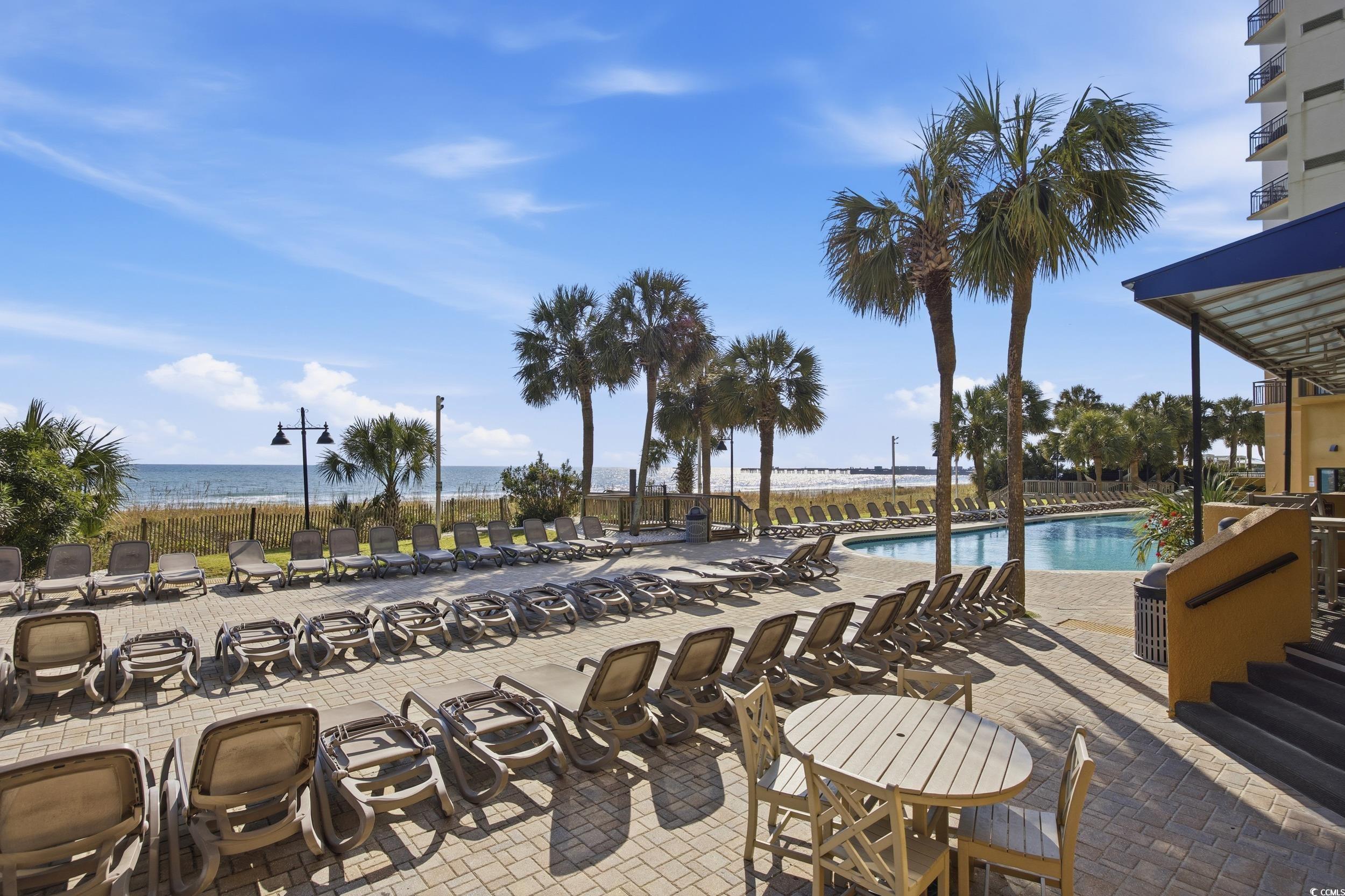 2710 North Ocean Boulevard, Unit 702 Myrtle Beach, SC 29577 - Photo 27 of 38 Community pool featuring a patio area and view of water and beach