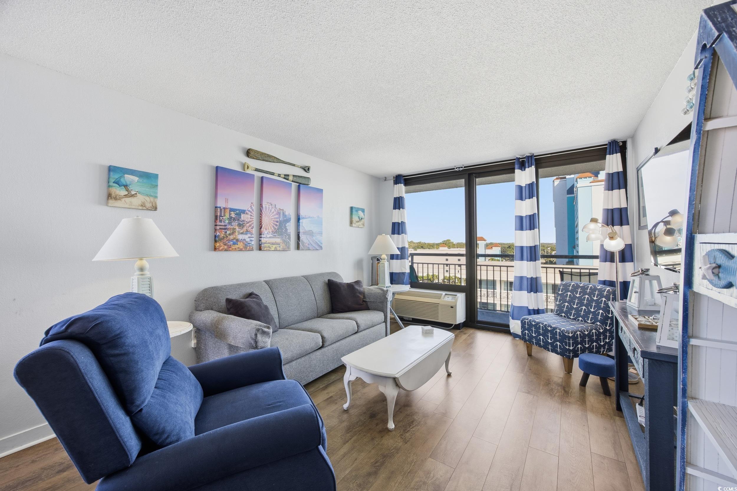 2710 North Ocean Boulevard, Unit 702 Myrtle Beach, SC 29577 - Photo 3 of 38 Living area with a textured ceiling, wood finished floors, and a wall of windows