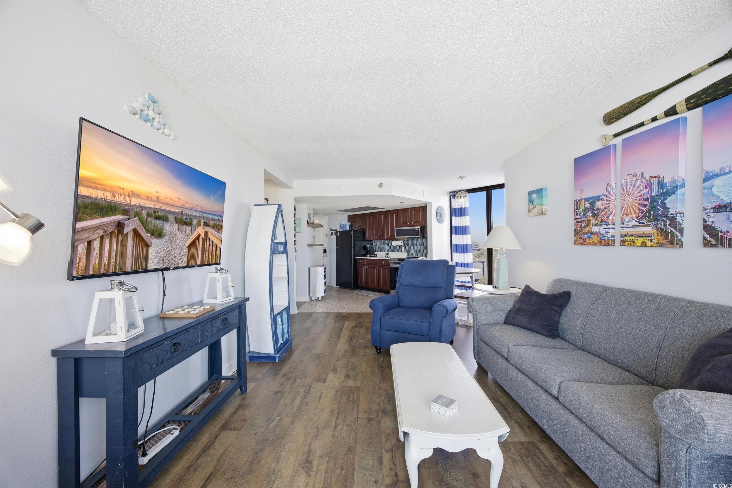 2710 North Ocean Boulevard, Unit 702 Myrtle Beach, SC 29577 - Photo 5 of 38 Living area featuring dark wood-type flooring and a textured ceiling