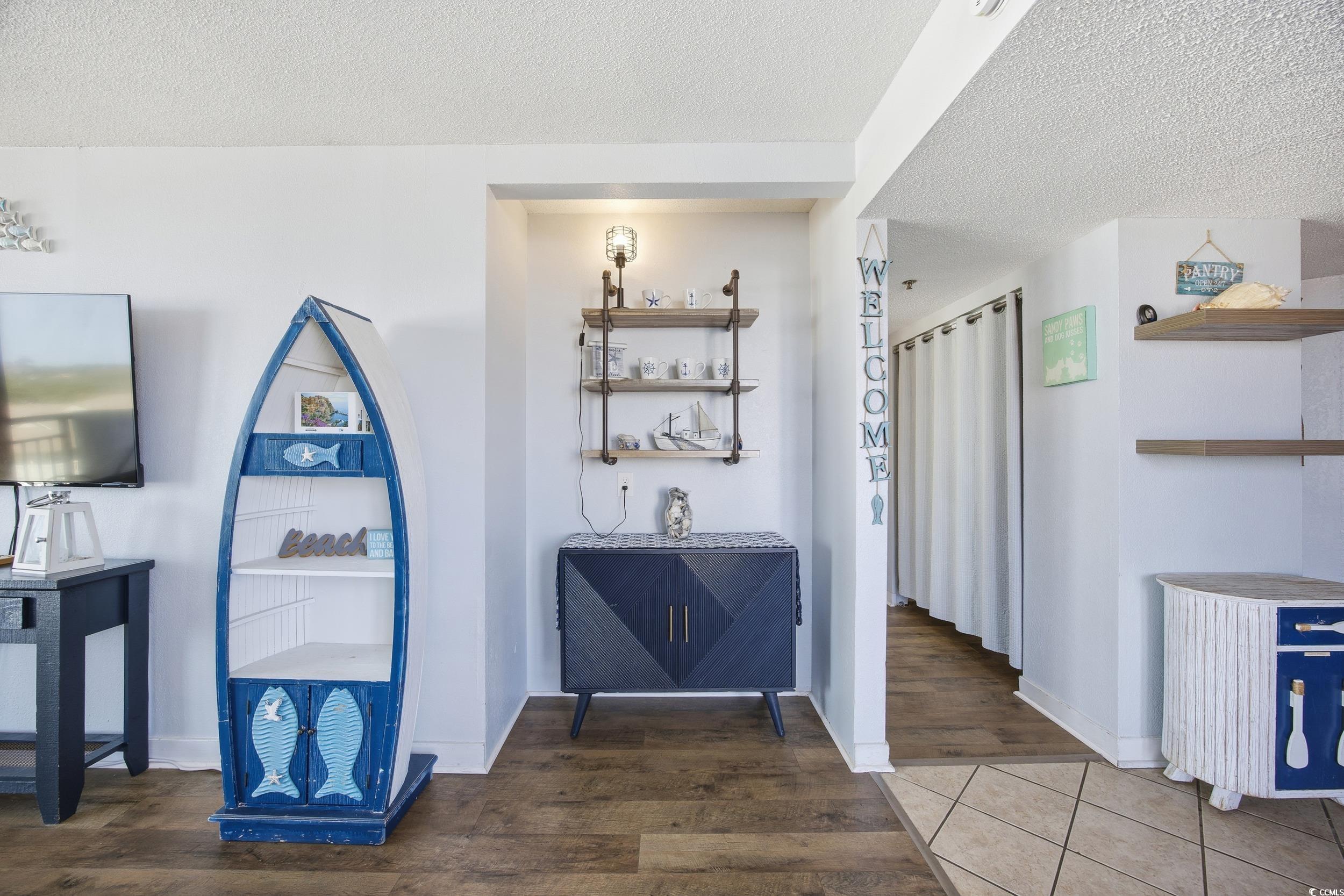 2710 North Ocean Boulevard, Unit 702 Myrtle Beach, SC 29577 - Photo 6 of 38 Bar area featuring open shelves, dark wood-type flooring, and a textured ceiling
