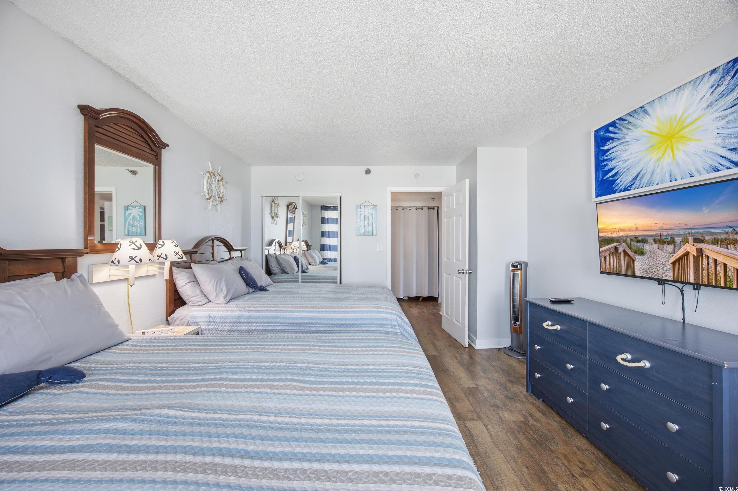 2710 North Ocean Boulevard, Unit 702 Myrtle Beach, SC 29577 - Photo 8 of 38 Bedroom with dark wood-style flooring, a textured ceiling, and wine cooler