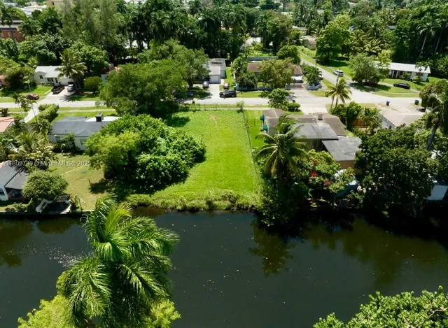 an aerial view of residential houses with outdoor space and lake view
