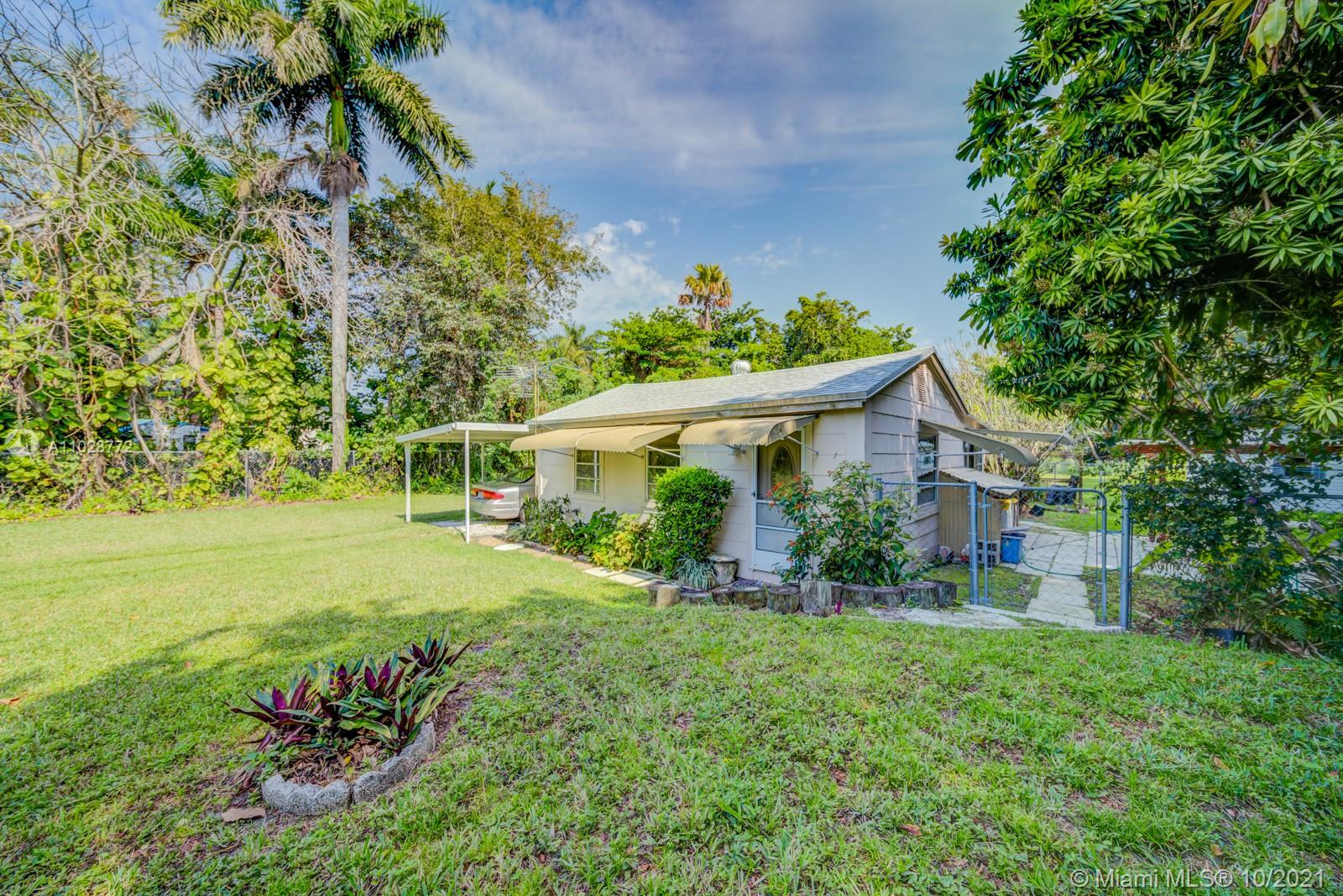 477 Northeast 154th Street Miami, FL 33162 - Photo 16 of 26 a front view of a house with a yard and potted plants