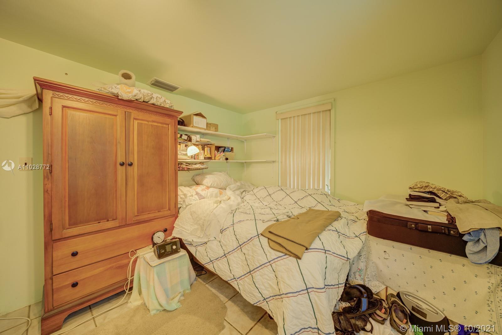 477 Northeast 154th Street Miami, FL 33162 - Photo 2 of 26 a bed room with a bed and furniture
