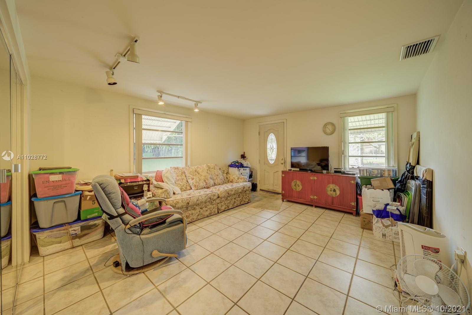 477 Northeast 154th Street Miami, FL 33162 - Photo 3 of 26 a living room with furniture and a window